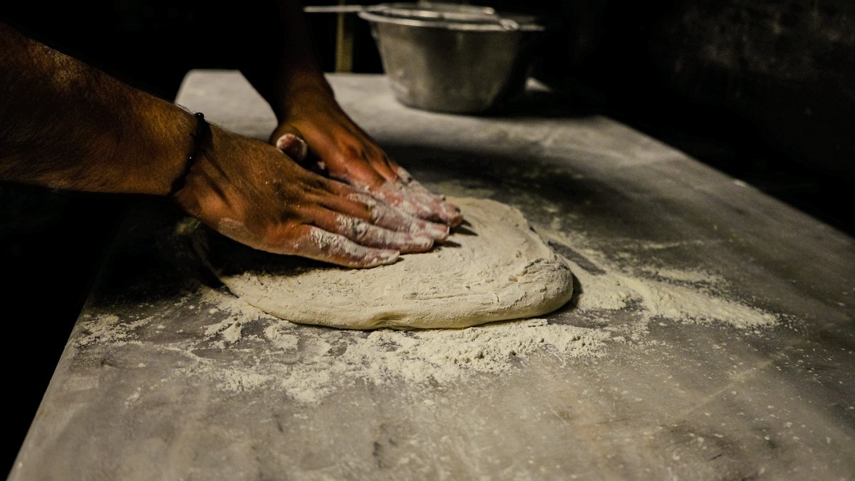 Hands kneading pizza dough at Pizza Dojo pizza making class in Kolkata