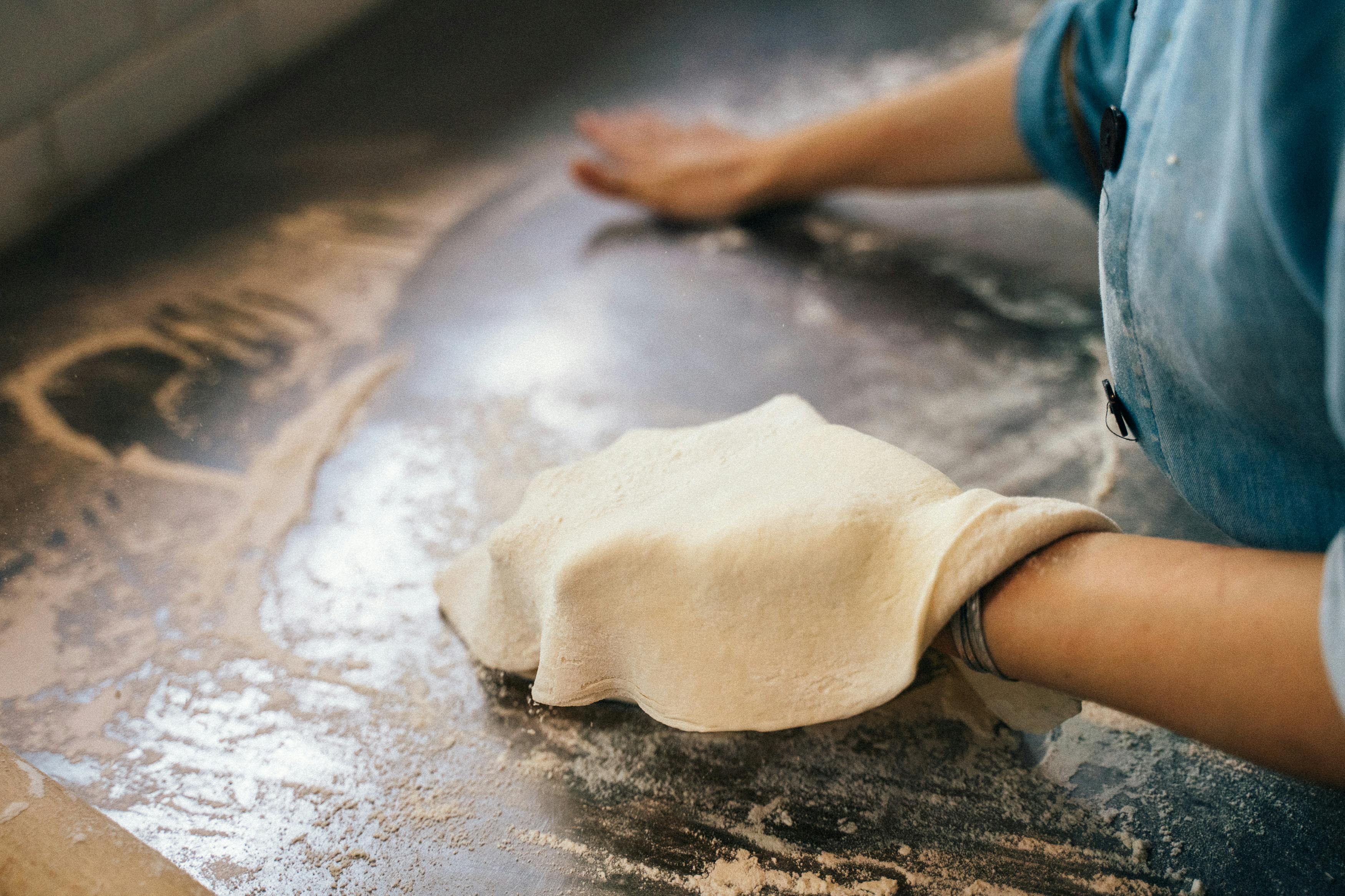 Hands stretching pizza dough at Pizza Dojo pizza making workshop in Kolkata