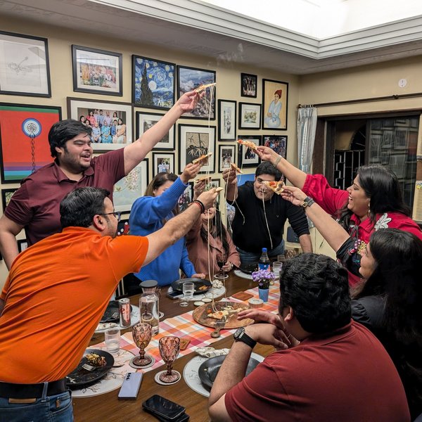 Guests at Pizza Dojo supper club dinner in Kolkata raising pizza slices together