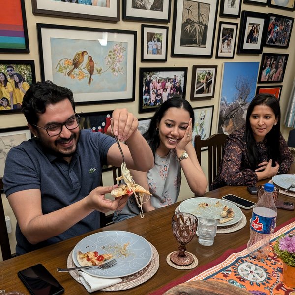Guests laughing and sharing pizza at Pizza Dojo community dinner Kolkata