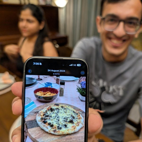 Guest showing pizza photo at Pizza Dojo intimate dining experience Kolkata